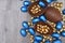 Pile or group of different sizes of colourful foil wrapped chocolate easter eggs in blue, and gold. Large halves of an egg.