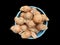 Pile of hairy coconut on plastic tub, on black background