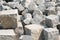 Pile of hard stone blocks of cubic form or shape and gray color