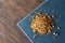 Pile of healthy granola on black stony board over vintage wooden background, top view, close-up, selective focus