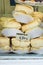 Pile of homemade baked meringues on a cake stand in display window of artisan bakery in a European city