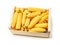 Pile of husked sweet corn cobs in wooden crate