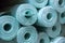 Pile of insulation material rolls. Light green or blue color. Filled frame.