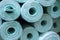 Pile of insulation material rolls. Light green or blue color. Filled frame.