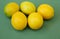 A pile of juicy lemons on a green background. Organic citrus fruits for a healthy diet. Copy space.