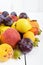 A pile of juicy summer fruits on white wooden background plums, apricots, pears.