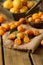 Pile of kumquat on jute canvas over the wooden table