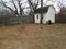 Pile of leaves with white shed and rain barrels