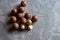 Pile macadamia nuts open kernels and shells on gray concrete background, top view