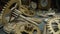 Pile of metal internal parts of an old clock. Clockwork, gears, cogwheels lie on the table on a blurred background of