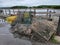 pile of metal lobster traps on dock near water