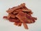 Pile or mound of bacon strips on white surface