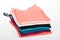 Pile of multicolored tank tops t shirt fabric cotton t-shirts pile of various colored shirts on white table background