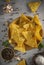 Pile of nachos, potato chips with spices lying in a wooden bowel. Concept of fast food background. Free place for text, top view