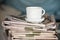 Pile of newspapers and coffee cup