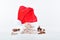 Pile of nougat blocks with an assortment of almonds and a Santa hat at the back on a light background. Traditional sweets and