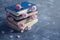 Pile of the old books and pink roses on the concrete background. Moody tones and soft focus shot