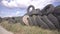 Pile of old car tyres storage. Stack of used tires junkyard. Heap black wheels ecology hazard. Illegal tire dump in the