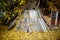 Pile of old doors and wooden boards on the background of the autumn landscape. Carpet of yellow autumn leaves. Garbage