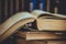 Pile of old opened books, row of volumes in the background, vintage style, education, reading concept, toned