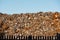 Pile of old rusty metal bits behind fence. Recycle industry concept. Tall pile of waste material. Clean blue sky. Scrap junk ready