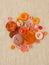 Pile of orange buttons on hessian