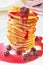 Pile of Pancakes with cherry jam in white plate on the table