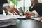 Pile of paperwork on meeting table with blurred businesspeople working on background