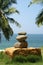 Pile of pebble Stones against the background of palm trees and the sea