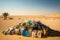 a pile of plastic bottles and other garbage in the middle of a desert