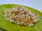 Pile of a Pongal Traditional Raw Mixtures of Ellu Bella in a Green Plate  on white Background