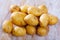 Pile of raw potatoes at wooden table in home kitchen