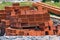 A pile of red perforated clay bricks