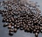 Pile of roasted coffee beans on dark gray surface