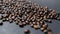 Pile of roasted coffee beans on dark gray surface