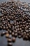 Pile of roasted coffee beans on dark gray surface