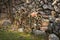 A pile of roofing tiles lying in front of a stone wall