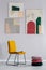 Pile of round velvet pillows next to yellow chair with open book in spacious interior