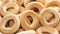 A pile of round yellow appetizing bagels rotates in a circle.