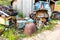 A pile of rusty scrap metal and truck tires in the backyard of a farm