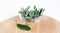 Pile of sage leaves in glass bowl and lone leaf on round wooden