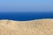 A pile of sand on a beach against the sea and sky