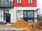 pile of sand and scaffolding at construction site near the under apartment building.