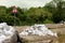 Pile of sandbags next to warning exclamation road sign and temporary flood protection wall made of box barriers covered with thick