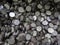 A pile of sawed cylindrical steel workpieces. Full frame close-up industrial background.