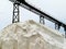 Pile of sea salt under conveyor of saline refinery