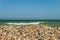 Pile of seashells on the seashore on a sunny day. Calm vacation background with limited depth of field.