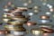 Pile of shiny coins different sizes and colors stacked unevenly on each other on colorful blurred blue abstract background. Money