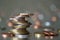 Pile of shiny coins different sizes and colors stacked unevenly on each other on colorful blurred blue abstract background. Money