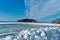 A pile of snow in front of a cleared rural roller